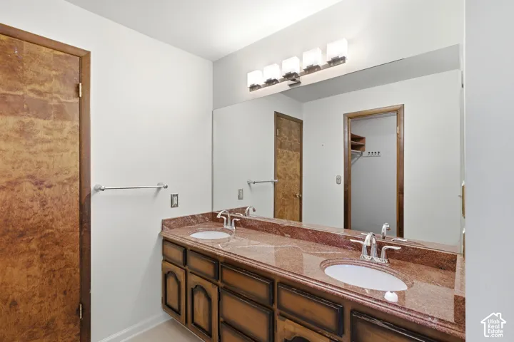 Dual vanity with integrated sinks, polished chrome fixtures, and a polished stone countertop