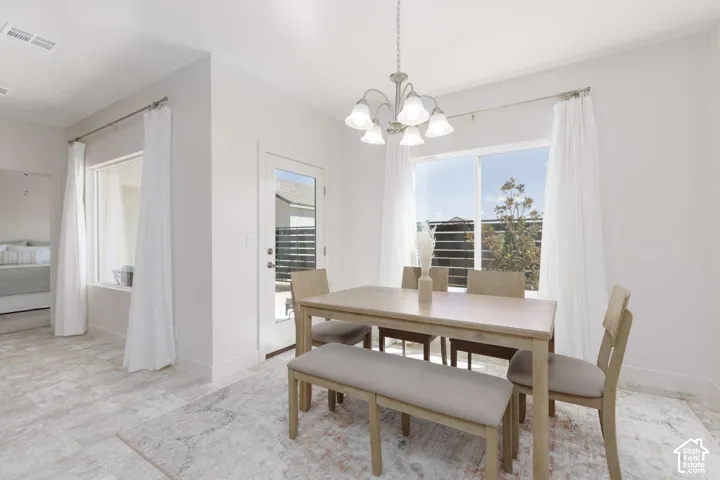 Recessed lighting, tiled flooring, built-in window seat, glass-paned exterior door, and a multi-light chandelier