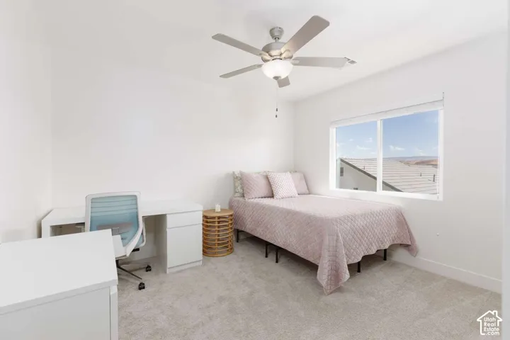 Recessed window with expansive outdoor scenery, overhead ceiling fan with integrated lighting, and neutral carpeting