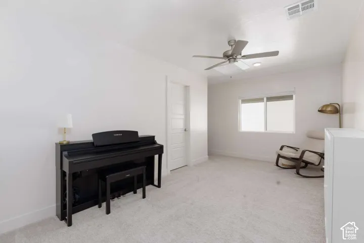 Recessed lighting, ceiling fan, white paneled door, window with horizontal blinds, and light-toned carpeting