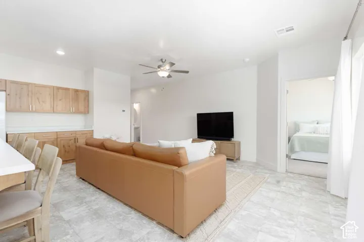 Open-concept living area with tiled flooring, recessed lighting, and a ceiling fan