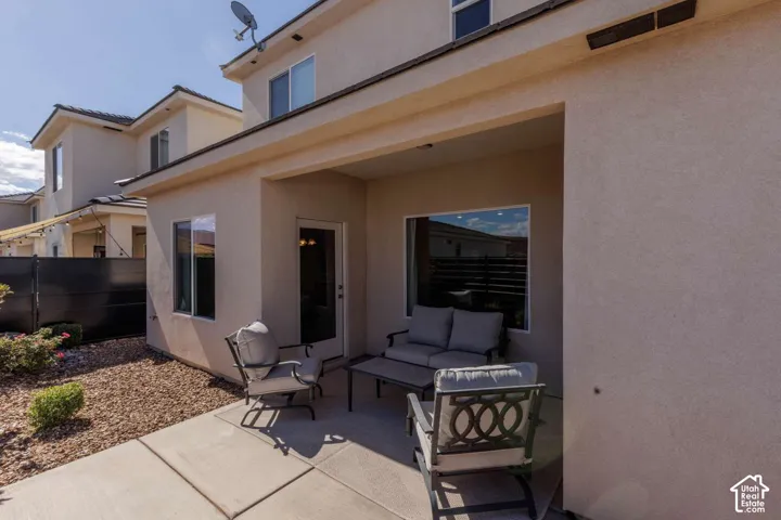 Covered patio with concrete flooring, stucco exterior, and a gravel landscape area