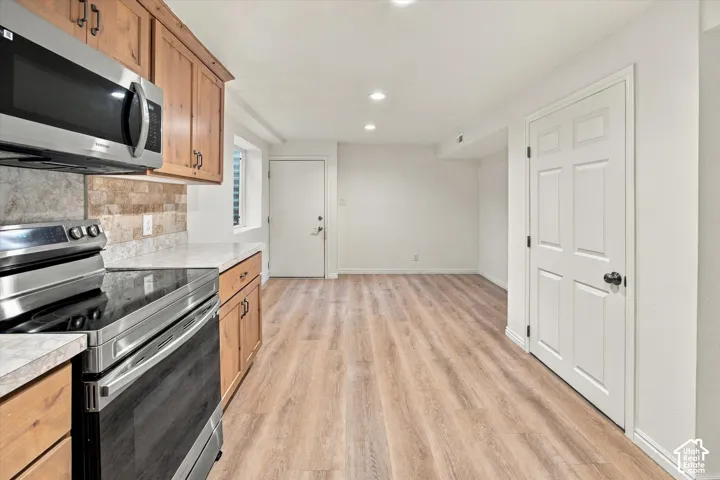 Wood-finish flooring, recessed lighting, and white walls
