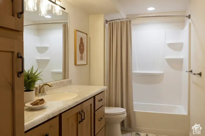 Vanity with wood-finish cabinetry, integrated sink, and brushed gold faucet