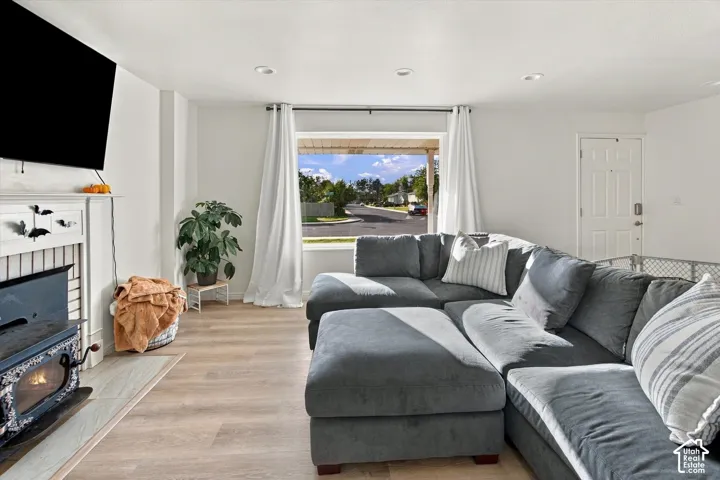 White interior walls, recessed ceiling lighting, wood-finish flooring, white window trim, and a white panel door