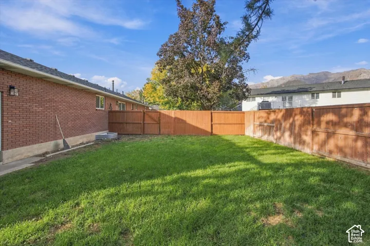 Manicured lawn with wood fencing and a brick exterior