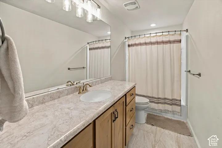 Light-toned vanity with an integrated sink and brass-finish faucet
