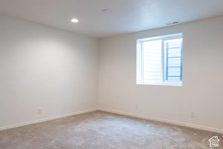 Wall-to-wall carpeting, recessed lighting, and a single window with blinds