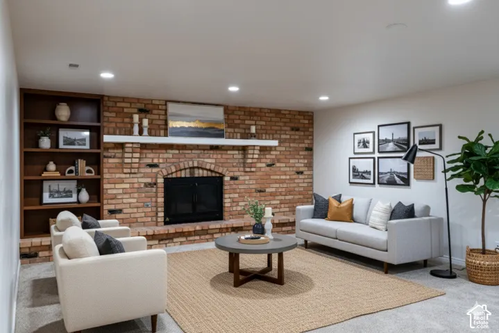 Exposed brick fireplace with an arched firebox and hearth, built-in shelving, and recessed lighting