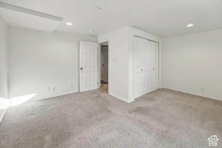 Recessed ceiling lighting, white interior doors, and neutral carpeting