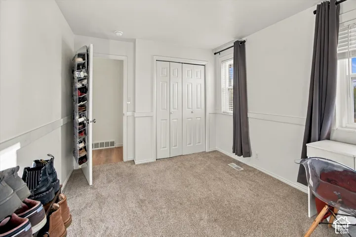 Wall paneling with integrated chair rail, light-toned carpeting, and bi-fold closet doors
