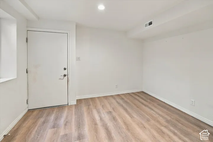 Wood-finish flooring with white baseboards and light-toned walls