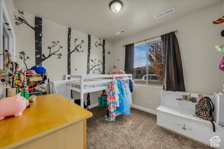 Carpeted room with a single window, white trim, and a ceiling-mounted light fixture
