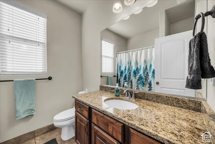 Bathroom featuring a vanity with granite countertop, an integrated sink, and an undermount cabinet