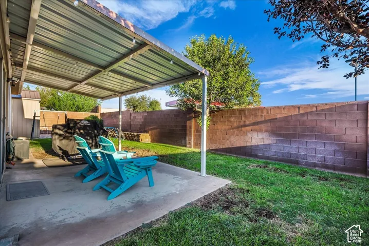 Covered patio with metal roof, concrete patio surface, and block privacy fence