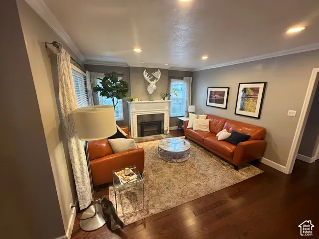 Living area with dark wood-finish flooring, recessed lighting, and crown molding