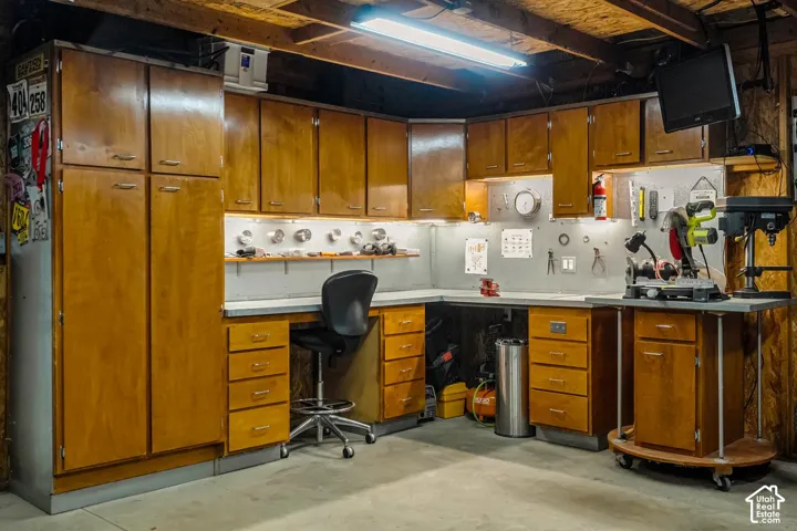 Extensive custom cabinetry, integrated workspace with under-cabinet lighting, durable countertop surfaces, and overhead fluorescent lighting