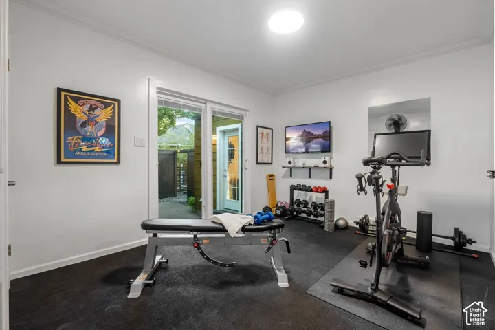 Dedicated exercise room featuring rubber flooring, a flush-mount ceiling light, and a sliding glass door