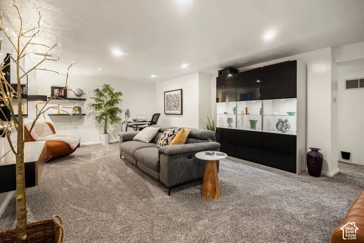 Built-in cabinetry with illuminated display shelves, recessed lighting, wall-mounted shelving, and carpet flooring