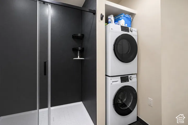 Walk-in shower with dark wall panels and a clear glass enclosure