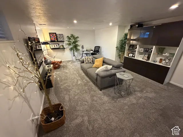 Recessed lighting illuminates the carpeted floor and built-in shelving