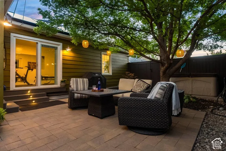 Entertainer's patio featuring a tile-paved surface, built-in seating with weather-resistant cushions, a low-profile fire table, and overhead ambient lighting