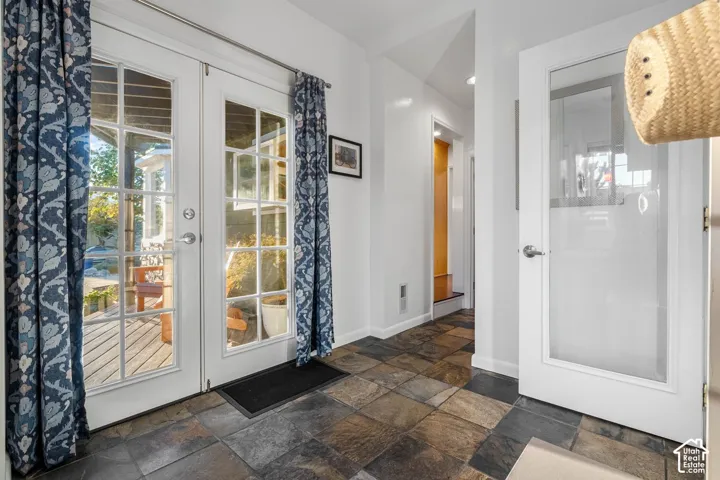 French doors with divided lites, slate tile flooring, recessed lighting, and a frosted glass panel door