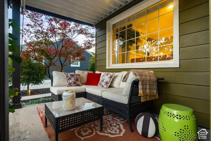 Covered patio with a concrete surface, featuring a large bay window, horizontal siding, and recessed lighting