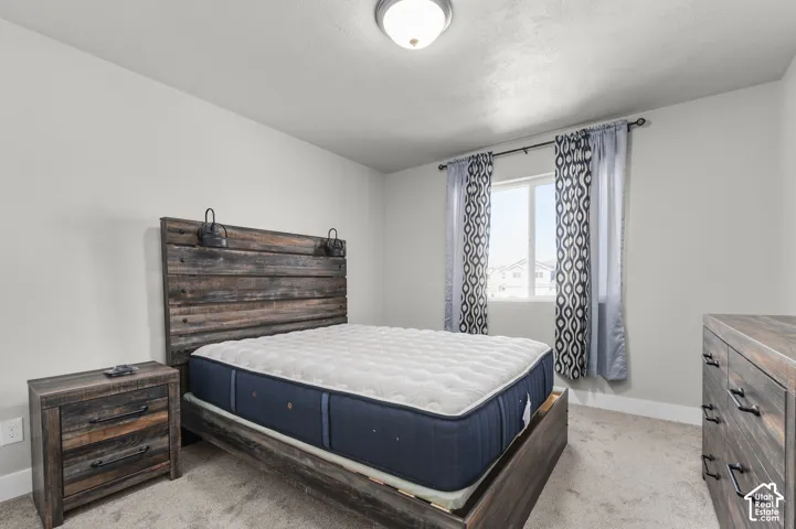 Carpeted flooring, white walls, and a window with a white frame