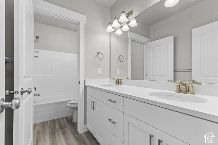 Dual vanity with white cabinetry, light countertops, and gold-tone faucets