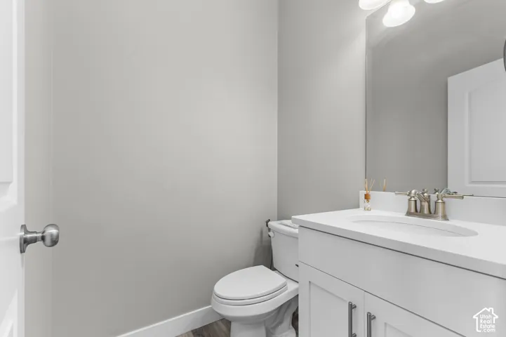 White vanity with brushed nickel hardware, integrated sink, and wall-mounted mirror