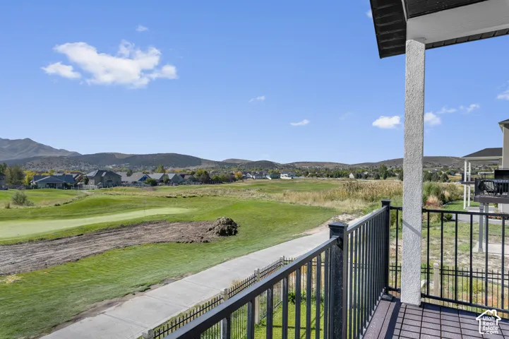Exterior deck with composite decking, black metal railing, and golf course frontage