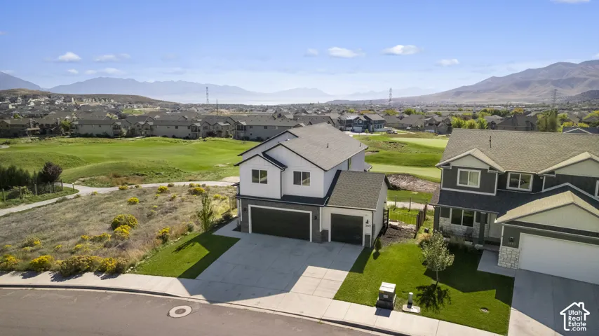 Two-story residence with a multi-car garage and a manicured lawn