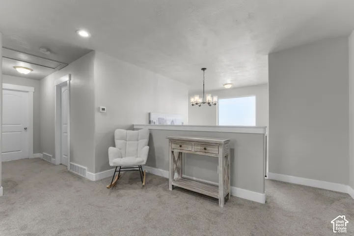 Recessed lighting, wall-to-wall carpeting, and a half-wall partition create distinct zones