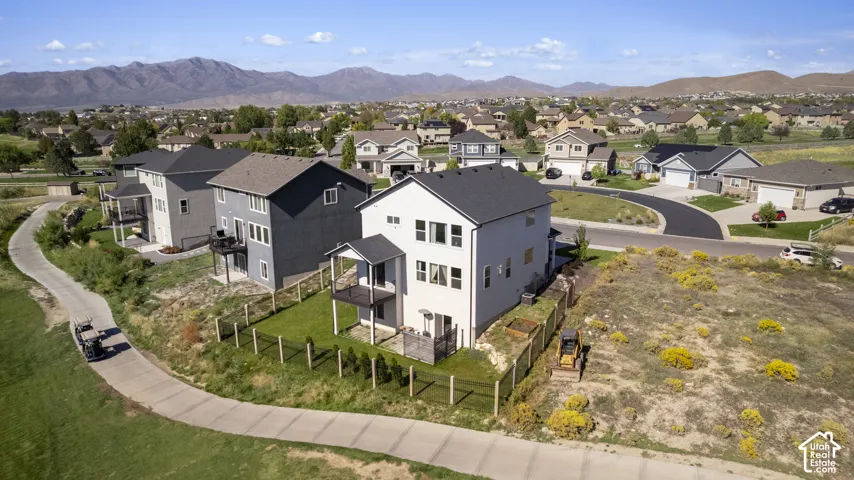 Modern residential architecture with a neutral exterior palette, adjacent to a paved pathway
