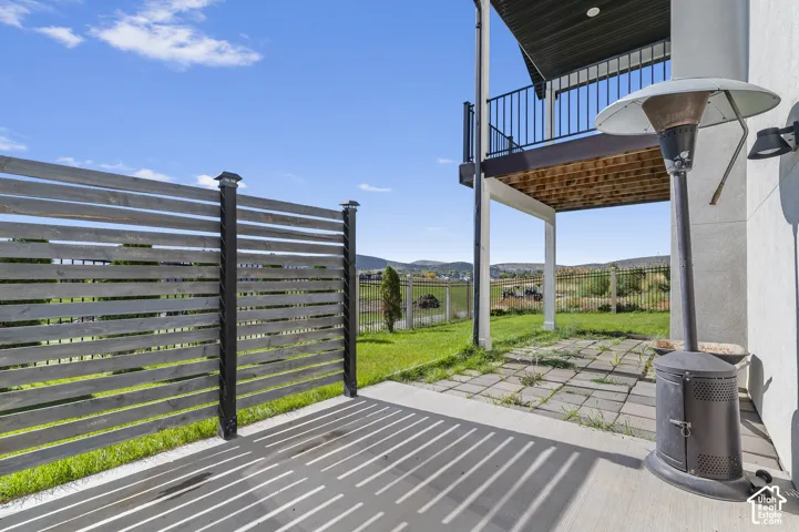 Ground-level concrete patio with a slatted privacy fence