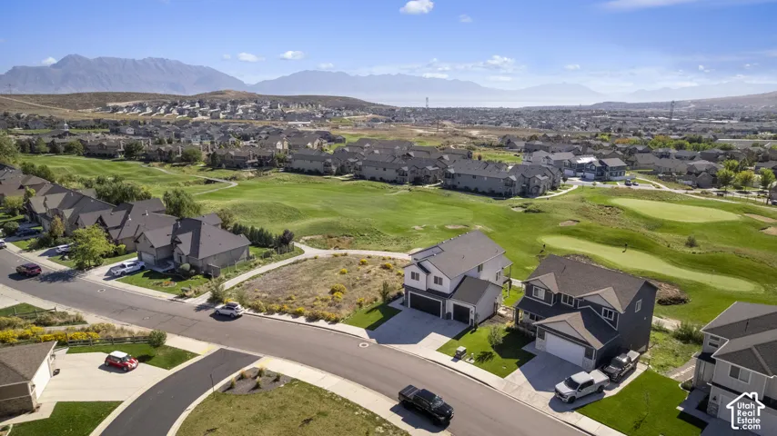 Residential community with mountain backdrop, golf course, and paved roads