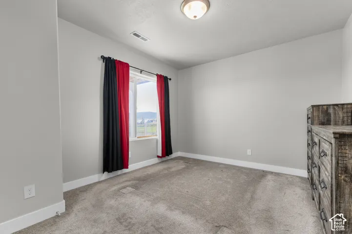 Carpeted room with a window, white trim, and a ceiling-mounted light fixture