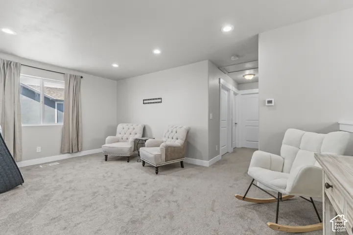 Recessed lighting, wall-to-wall carpeting, and white trim accents define this interior space