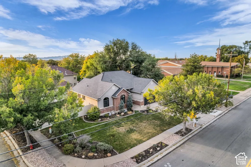 Brick and stucco exterior with arched windows, mature landscaping, and a well-maintained lawn
