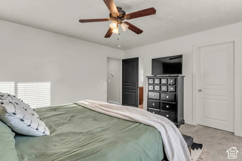 Carpeted room featuring a ceiling fan with integrated lighting, white walls, and white trim