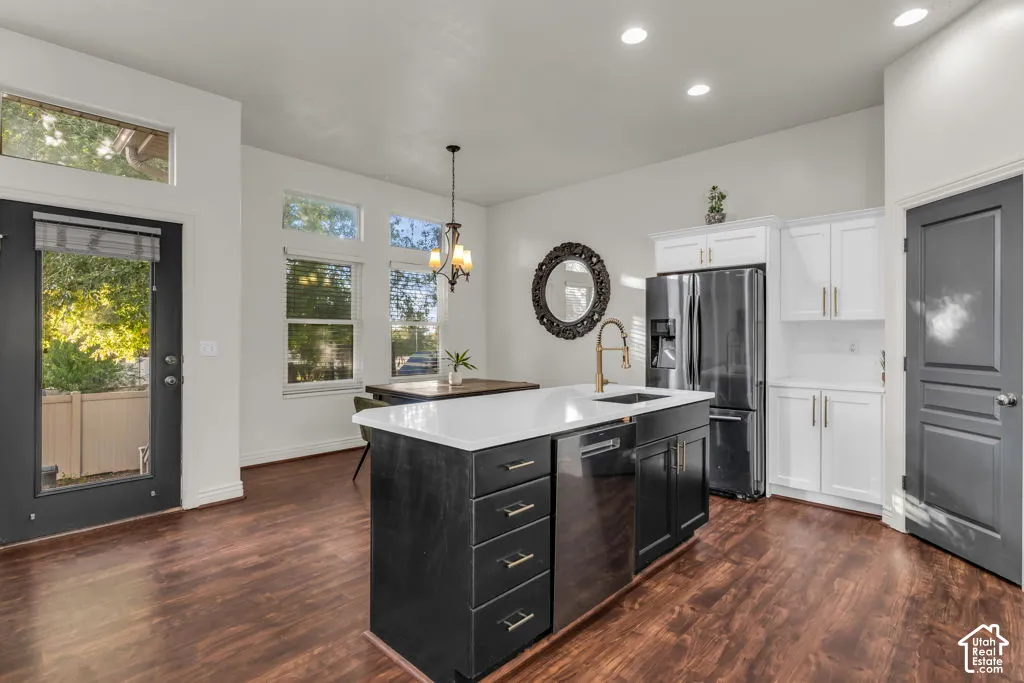 Kitchen featuring a large island with sink, stainless steel appliances, dark wood-finish flooring, and white cabinetry