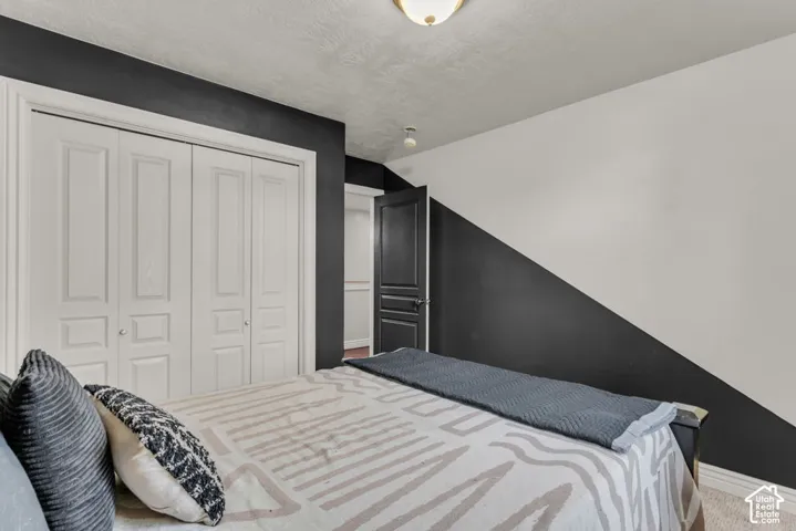 Built-in bi-fold closet doors, wall-mounted light fixture, and a contrasting accent wall with a geometric design