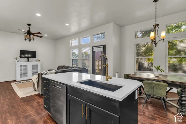 Kitchen island with white countertop, integrated sink, and bronze-finish faucet