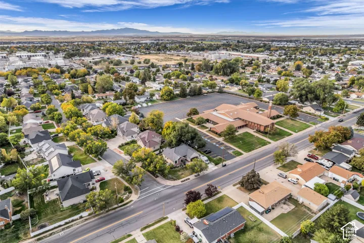 Aerial perspective highlighting residential properties and a large community building with extensive parking