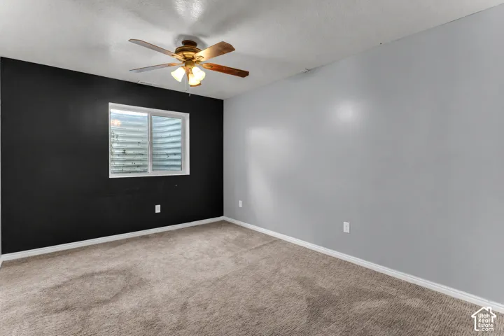 Recessed window, textured carpeting, and a ceiling fan with integrated lighting