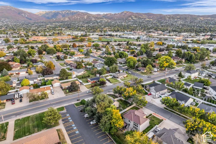 Expansive neighborhood with established residential properties and mature trees, set against a backdrop of mountain ranges