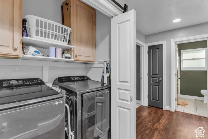 Laundry area with upper cabinetry and a sliding barn door