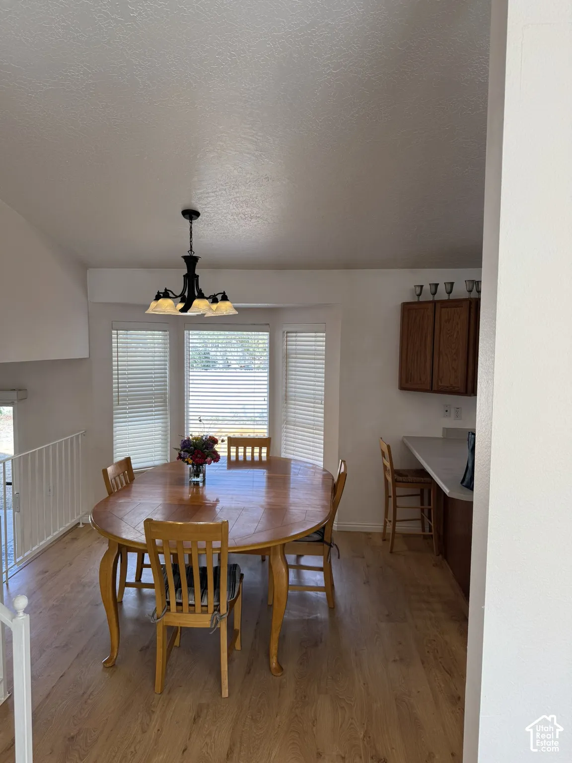 Wood-finish flooring throughout, bay window with blinds, and a built-in kitchen counter