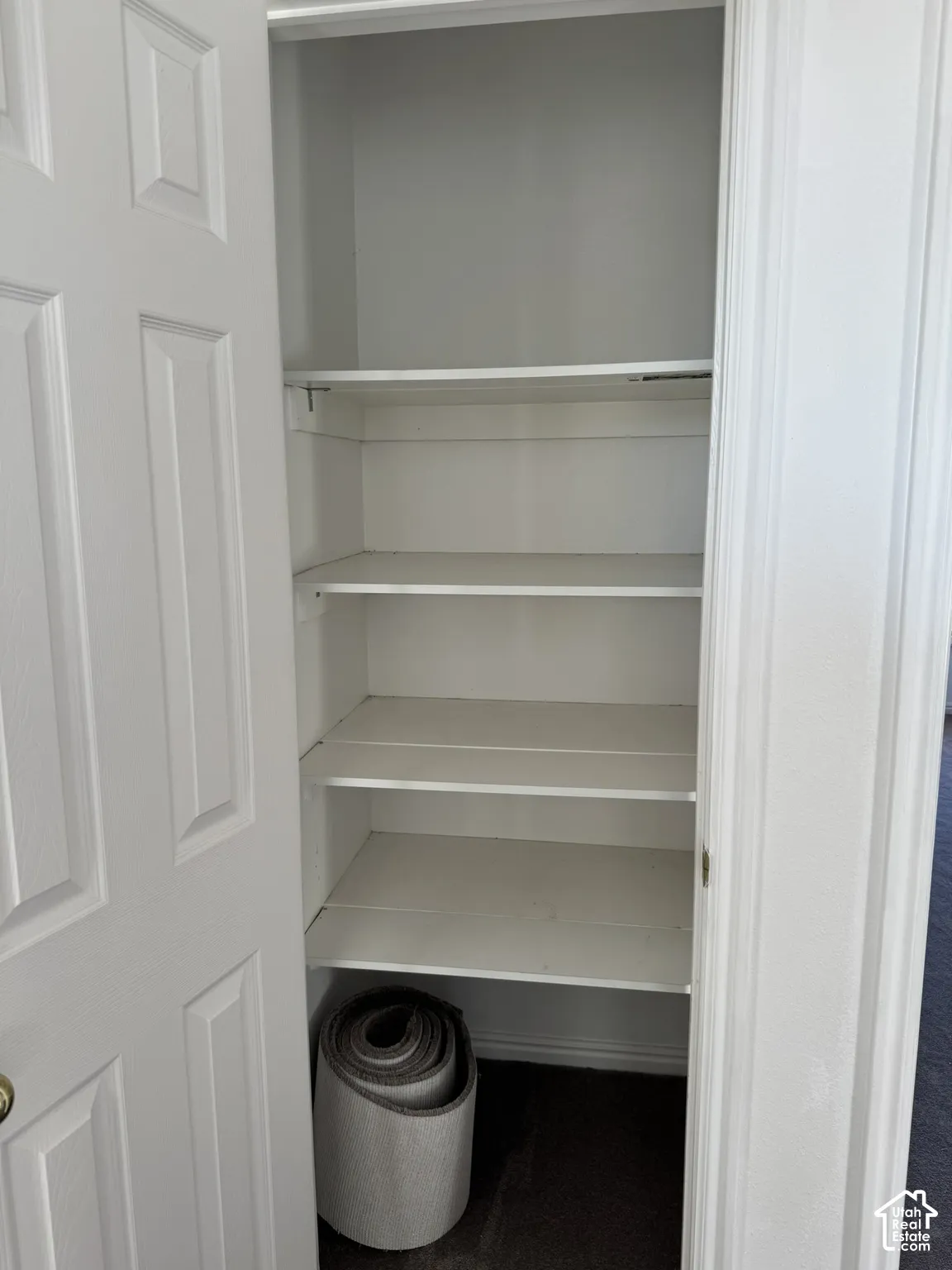 Recessed closet with multiple white shelving units